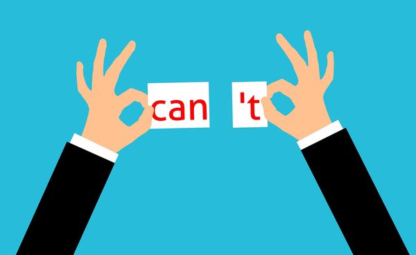 Obrazek dekoracyjny przedstawiający ręce rozrywające karteczkę z napisem "can't" na dwie z napisami: "can" i "'t"
