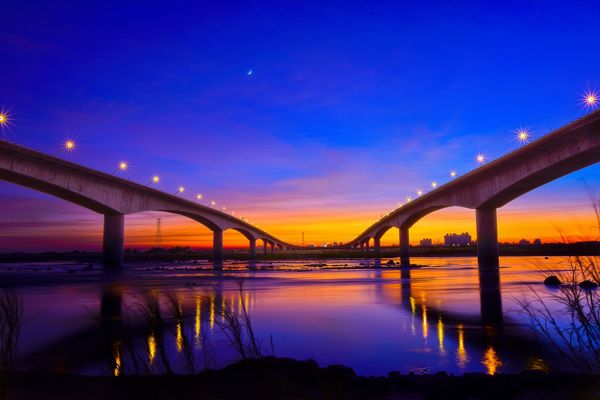 Zdjęcie przedstawia most w Tajwanie o wschodzie słońca