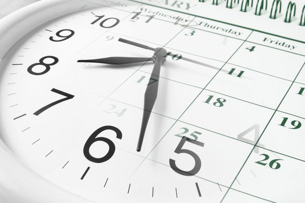 Zdjęcie przedstawia zegar i kalendarz