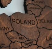 obrazek dekoracyjny przedstawiający drewnianą mapę z Polską i jej sąsiadującymi krajami