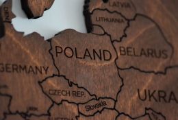 obrazek dekoracyjny przedstawiający drewnianą mapę z Polską i jej sąsiadującymi krajami
