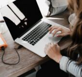obrazek dekoracyjny -kobieta pracująca na laptopie przy stole
