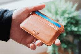 Wyciągnięta ręka z portfelem i kartami płatniczymi