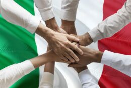 Złączone ręce nad flagą Włoch