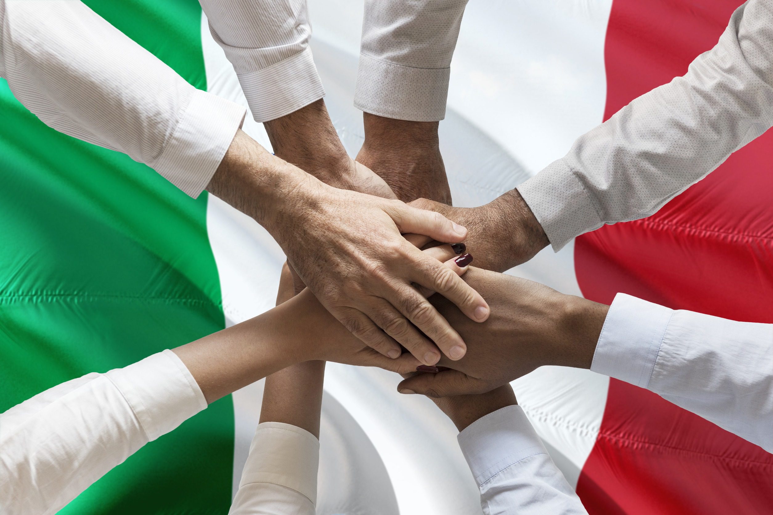 Złączone ręce nad flagą Włoch