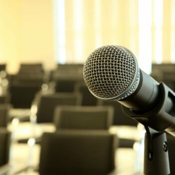 Mikrofon, w tle krzesła konferencyjne