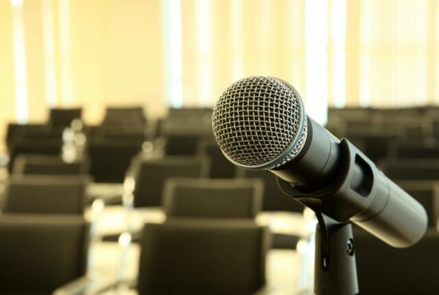 Mikrofon, w tle krzesła konferencyjne