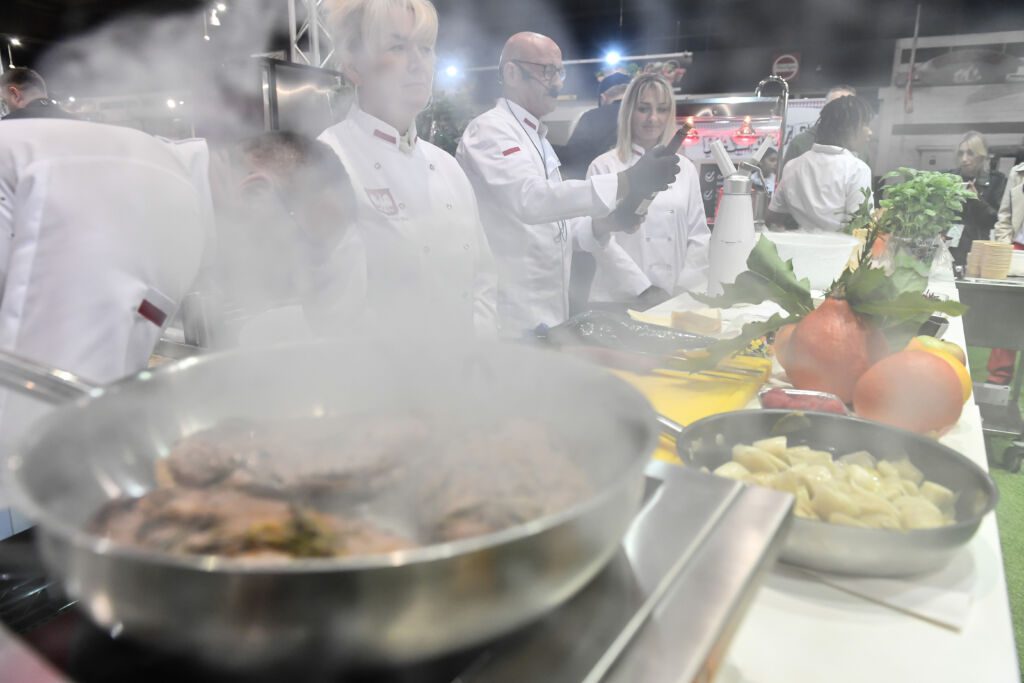 Kucharze w białych kitlach prezentują sztukę kulinarną podczas wydarzenia Polska Noc na MaBru