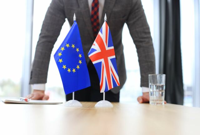 Flaga UE i UK, w tle biznesmen