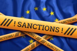 Napis sankcje na wstędze na tle flagi UE