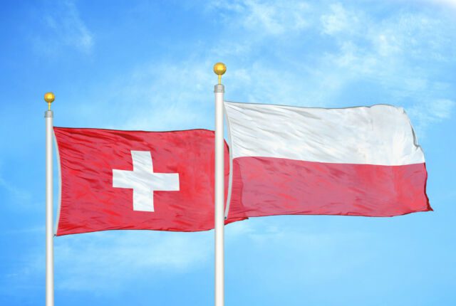 Flagi Polski i Szwajcarii, w tle błękitne niebo