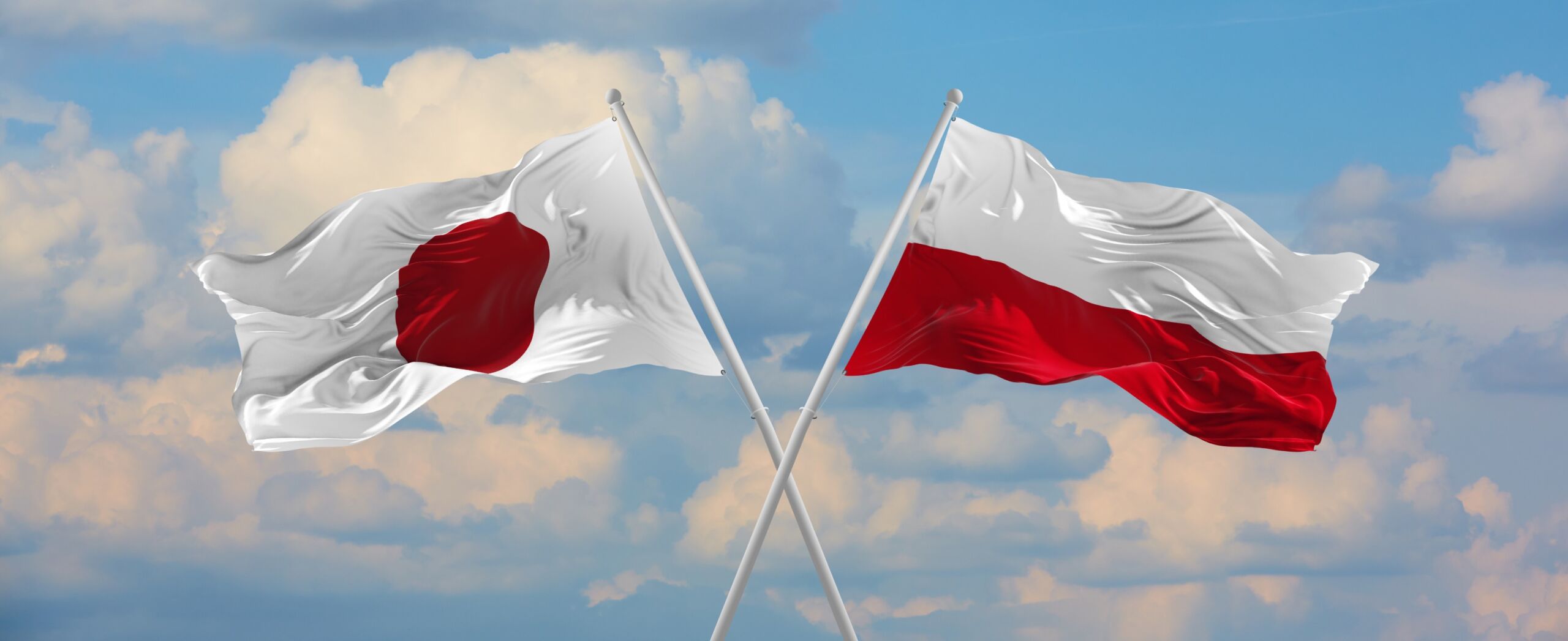 Flaga Japonii i Polski powiewają na wietrze