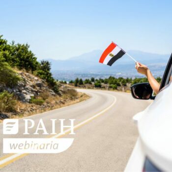 Osoba wyciąga rękę z samochodu z flagą Egiptu