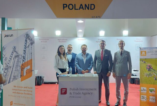 pracownicy PAIH stojący na tle logo Agencji