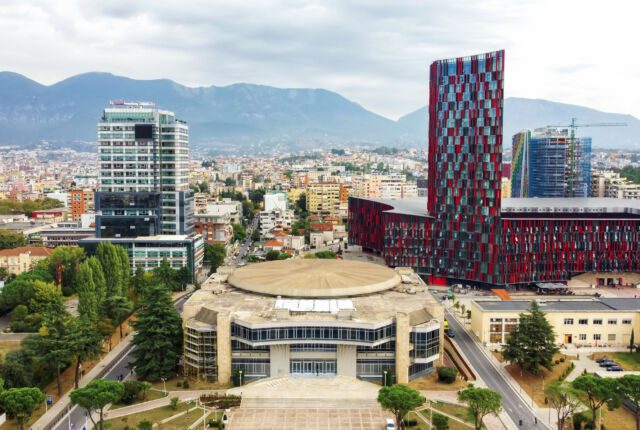 Albania - widok z lotu ptaka na centrum Tirany w Albanii z nowoczesnymi budynkami, stadionem, dzielnicą mieszkaniową i górami w oddali