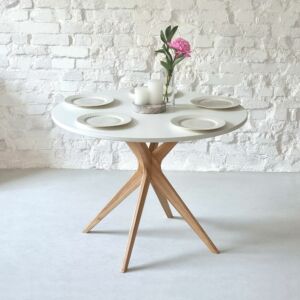 Round table on one central wooden leg. White top made from MDF.