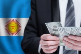 flaga Argentyny i biznesmen liczący pieniądze