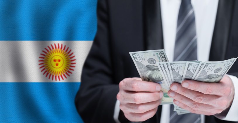 flaga Argentyny i biznesmen liczący pieniądze