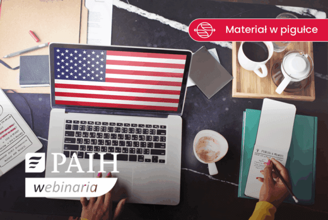 biurko, na nim laptop a na pulpicie flaga USA