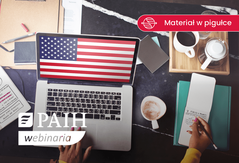 biurko, na nim laptop a na pulpicie flaga USA
