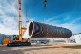 dźwig, ktory unosi fragment rury budowlanej