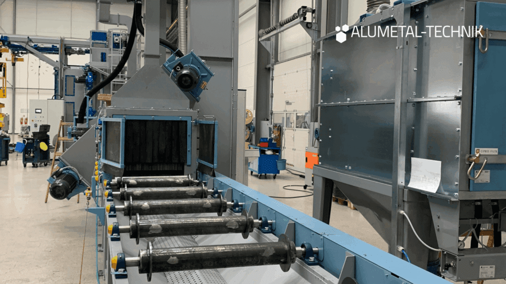 Pass-through blasting machine TZNP in the shot blasting room of an industrial company.