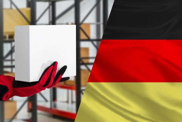 maczka w dłoni i fragment niemieckiej flagi