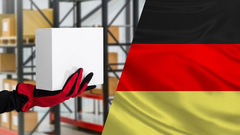 maczka w dłoni i fragment niemieckiej flagi