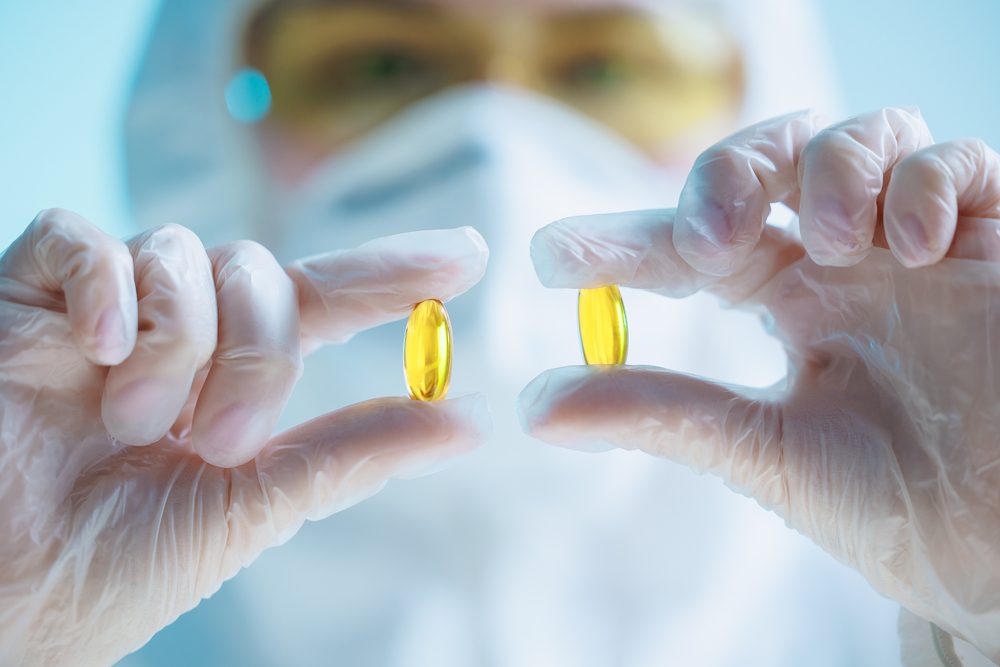 Medyk trzyma żółte kapsułki