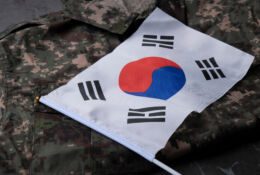 Flaga Korei Południowej na tle munduru wojskowego
