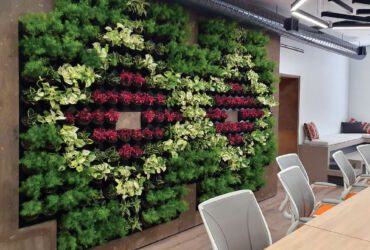 A permanent green wall with a floral arrangement.
