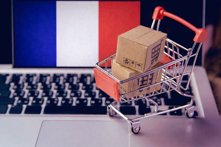 kosz z zakupami na klawiaturze laptopa i flaga Francji