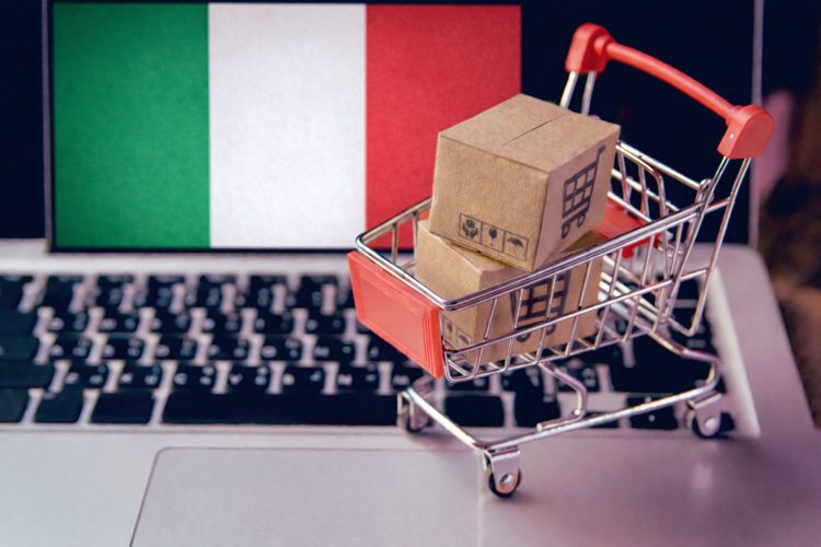 koszyk z zakupami na klawiaturze laptopa i flaga Włoch