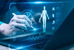 Osoba wskazująca na ikony medyczne i schemat ciała człowieka na ekranie laptopa