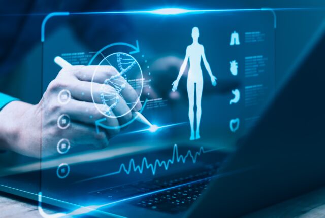 Osoba wskazująca na ikony medyczne i schemat ciała człowieka na ekranie laptopa